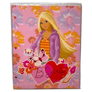 May include: A pink binder featuring a cartoon illustration of a blonde woman wearing a purple jacket and an orange and yellow striped top. The binder is decorated with flowers, butterflies, and the words "B Girly Barbie" in a heart-shaped design.