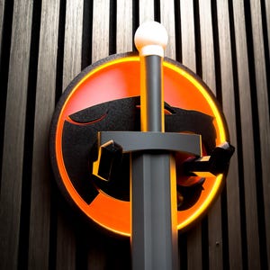 Puede incluir: Una espada negra y gris con un pomo blanco está montada sobre un emblema circular naranja y negro. El emblema presenta una silueta de gato estilizada, sobre un fondo de listones de madera oscura.