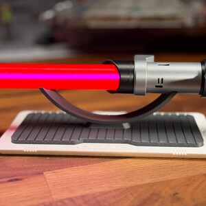 May include: A white ceramic mug with a black handle and the text "But first, coffee" in a black, handwritten-style font. The mug is on a white surface.