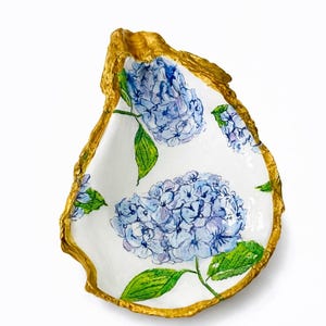 May include: A set of three ceramic mugs with a speckled, matte finish. Each mug features a different color: light blue, cream, and gray. The mugs have a simple, modern design and a comfortable handle.