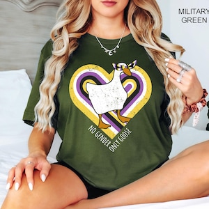 May include: A green t-shirt with a white goose wearing sunglasses in a heart-shaped design with yellow, purple, and black stripes. The text "No Gender Only Goose" is below the goose.