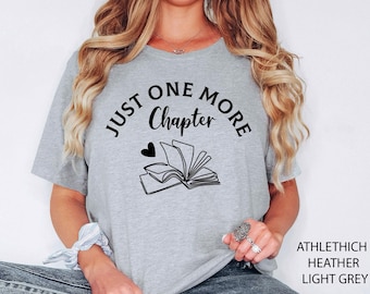 May include: Light grey t-shirt with the text "JUST ONE MORE Chapter" above a graphic of an open book and a heart. The shirt also has the text "ATHLETHICH HEATHER LIGHT GREY" on the bottom right.