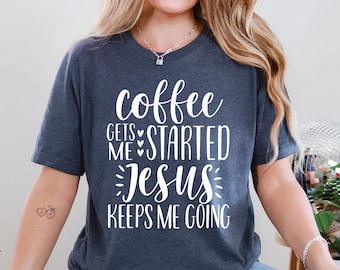 May include: Dark blue t-shirt with white text that reads "coffee gets me started Jesus keeps me going". The shirt has short sleeves and a crew neck. The text is in a handwritten style font.