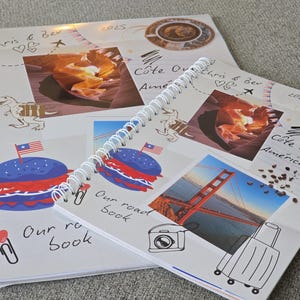 May include: Two white spiral bound notebooks with colorful images and handwritten text. The top notebook has a red, white, and blue burger, a dinosaur, and the text "Our road book". The bottom notebook has a photo of the Golden Gate Bridge, a suitcase, and the text "C&ocirc;te Quest Am&eacute;ricaine".