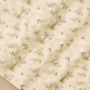 May include: A cream-coloured wallpaper featuring a repeating pattern of small brown birds perched on delicate tree branches with green leaves. The design has a soft, watercolour-like texture with subtle diagonal shading across the surface.