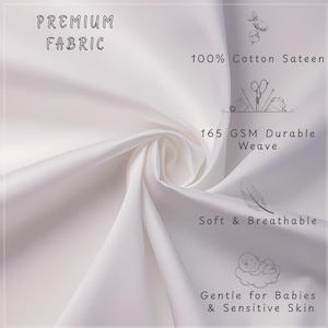 May include: Close-up of white fabric with the text "PREMIUM FABRIC". The image highlights the fabric's features: 100% Cotton Sateen, 165 GSM Durable Weave, Soft & Breathable, and Gentle for Babies & Sensitive Skin.