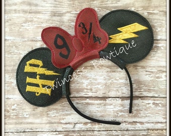 May include: Black headband with two black and green glitter mouse ears. One ear has a yellow lightning bolt and the other has a red bow with the numbers 9 3/4.