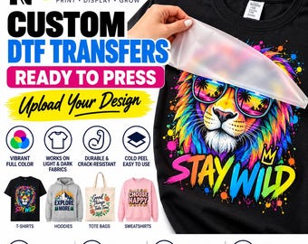 May include: A black t-shirt featuring a colorful lion graphic wearing sunglasses with the text STAY WILD. The design is a DTF transfer being applied to the fabric. The image includes text promoting custom DTF transfers and various apparel examples.