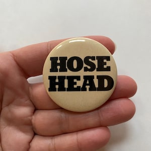 May include: A beige button with black text that reads "HOSE HEAD".