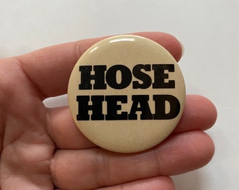 May include: A beige button with black text that reads "HOSE HEAD".