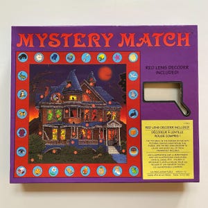 May include: A purple box for a "Mystery Match" jigsaw puzzle, featuring a spooky house illustration. The box includes a red lens decoder. The text on the box says "Red Lens Decoder Included!" and "100 Piece Jigsaw Puzzle Ages 8-10".