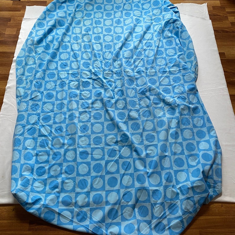 May include: A blue and white patterned bed sheet with a geometric design of circles and squares.
