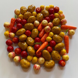 以下が含まれることがあります： 赤いリンゴ、黄色の洋梨、オレンジ色のニンジン、茶色のジャガイモなど、ミニチュアのプラスチック製の果物と野菜のコレクションです。