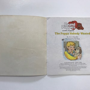May include: A Golden Book titled "The Puppy Nobody Wanted" by A.C. Chandler, illustrated by Pat Paris. The cover features a young boy in a yellow shirt holding a small white puppy. The book is part of the Pound Puppies series.