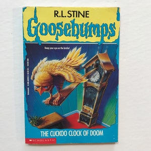 May include: A Goosebumps book cover featuring a yellow bird with red eyes perched on a cuckoo clock. The clock is tilted and the bird is looking at the viewer. The book title is "The Cuckoo Clock of Doom" and the author is R.L. Stine.