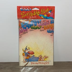 Peut inclure: Un bloc-notes "Giggles Scribble Pad" scellé avec 30 feuilles. La couverture présente un monstre de dessin animé au téléphone et les mots "Phone messages". Le fond a "Blah!" en plusieurs couleurs. Le haut a un oiseau de dessin animé.