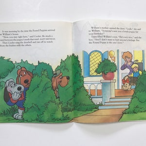 May include: A group of cartoon dogs hiding in bushes, with one dog holding a card that says "Happy Birthday". A boy in a wheelchair receives a puppy from his mother. The scene is from a children's book.
