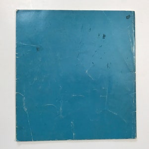 May include: A solid blue paper cover with some light scratches.