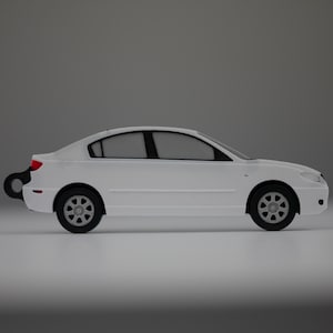 Könnte beinhalten: Ein weißes Spielzeugauto mit schwarzen Rädern und Fenstern. Das Auto hat einen Aufziehschlüssel hinten und ein rotes Rücklicht. Die Seitenansicht des Autos vor grauem Hintergrund.