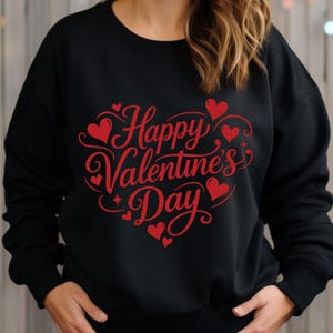 May include: Black sweatshirt with a red heart-shaped design that reads "Happy Valentine's Day." The design includes hearts and decorative flourishes. A casual, comfortable top for Valentine's Day.