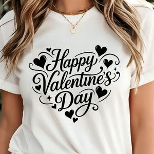 May include: White t-shirt with a black heart-shaped design that says "Happy Valentine's Day". The design includes hearts and decorative swirls. The shirt is a short-sleeved, casual style.