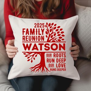 May include: White square pillow with a red family tree design. The text reads "2025 Family Reunion Watson" with the phrases "Our Roots Run Deep" and "Our Love Runs Deeper" below the family name. The pillow is held by a person.