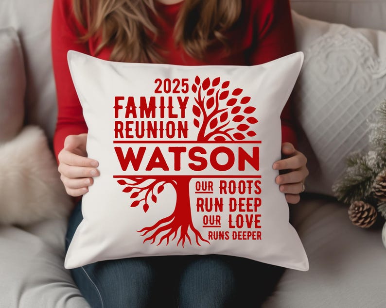 May include: White square pillow with a red family tree design. The text reads "2025 Family Reunion Watson" with the phrases "Our Roots Run Deep" and "Our Love Runs Deeper" below the family name. The pillow is held by a person.