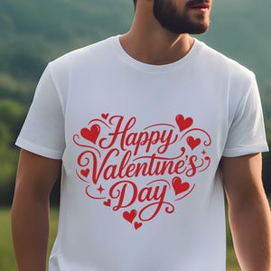 May include: White t-shirt with a red heart-shaped design that says "Happy Valentine's Day". The design includes hearts and decorative swirls. The shirt is made of a soft material.