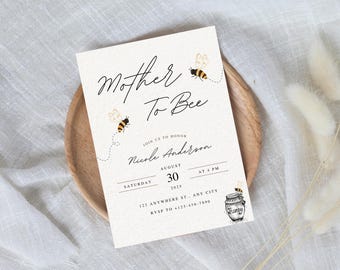 May include: A cream-colored invitation with the text "Mother To Bee" in elegant script, adorned with illustrated bees. The invitation includes details for a baby shower, including the date, time, and location.