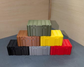 Könnte beinhalten: Ein Stapel aus sechs kleinen, rechteckigen Boxen in verschiedenen Farben, darunter Schwarz, Braun, Grau, Grün, Gelb und Rot. Die Boxen sind pyramidenförmig gestapelt.