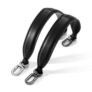 May include: Two black leather bag handles with silver-tone metal clasps. The handles are curved and padded, designed for comfort. The clasps are attached to the ends of the handles, ready for attachment to a bag.