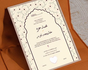 May include: A framed marriage certificate featuring a cream-colored background with a delicate floral pattern and a central arch design. The text includes names in Arabic script, English details about the ceremony, the date March 10, 2026, and a heart.