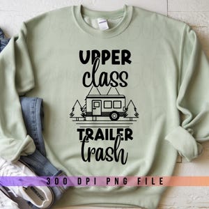 May include: A light green sweatshirt with the text "UPPER class TRAILER trash" in black. The graphic includes a trailer and trees. The bottom of the image has the text "300 DPI PNG FILE".