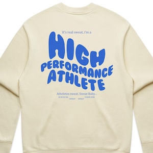 Può includere: Felpa color crema con la scritta blu "HIGH PERFORMANCE ATHLETE" e testo aggiuntivo. Girocollo e maniche lunghe. Design casual e sportivo.