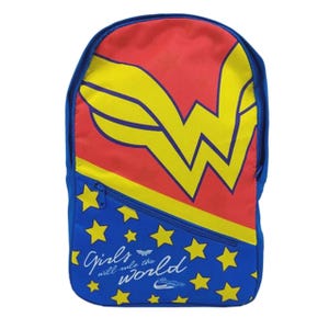 May include: A backpack featuring a red upper section with a large yellow Wonder Woman logo. The lower blue section is decorated with yellow stars and the white text Girls will rule the world, along with a small Wonder Woman emblem and logo.