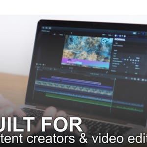 Op de afbeelding: Een laptop met videobewerkingssoftware met een kleurrijke video-tijdlijn. De tekst "BUILT FOR content creators & video editors" staat onderaan. De laptop staat open op een houten oppervlak.
