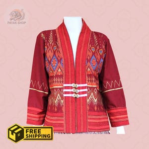 May include: A burgundy jacket with intricate patterns in red, gold, and blue. The jacket features a mandarin collar, long sleeves, and three decorative buttons. The text "PAYAK SHOP" is visible in the upper left corner. The jacket is displayed on a mannequin.