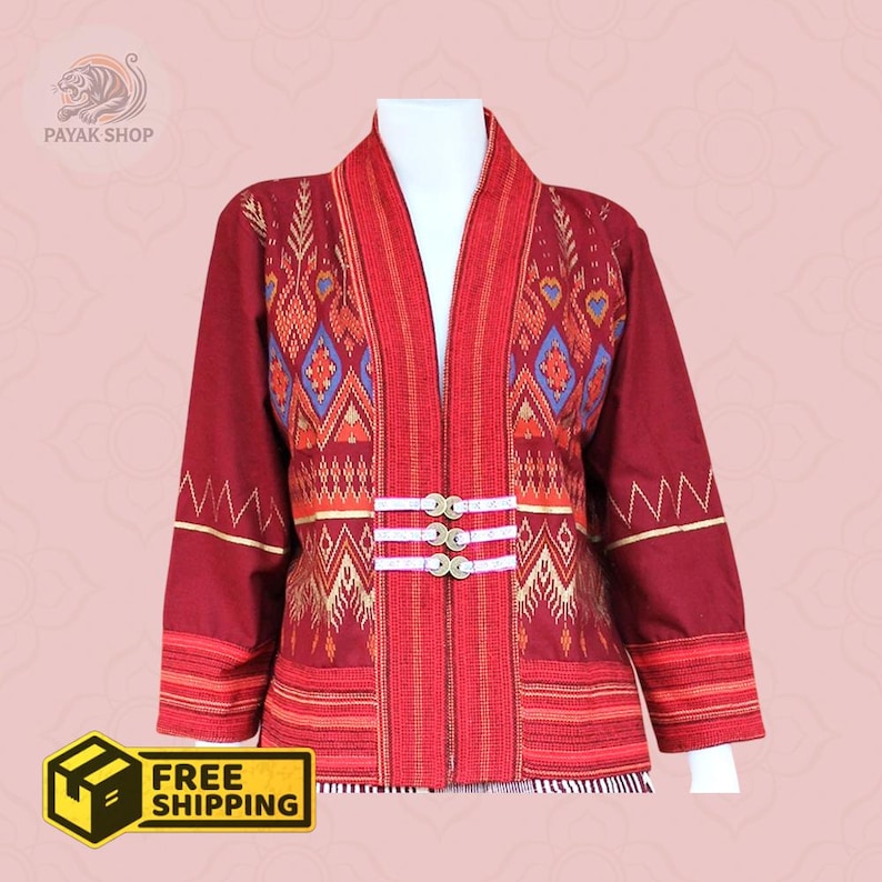 May include: A burgundy jacket with intricate patterns in red, gold, and blue. The jacket features a mandarin collar, long sleeves, and three decorative buttons. The text "PAYAK SHOP" is visible in the upper left corner. The jacket is displayed on a mannequin.
