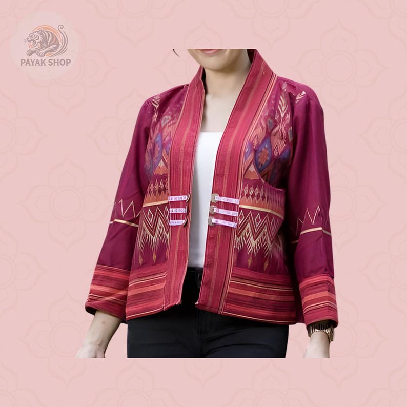 May include: A burgundy open-front jacket with intricate gold and orange geometric patterns. The jacket features a mandarin collar, three-quarter sleeves, and decorative closures. The jacket is part of a clothing collection.