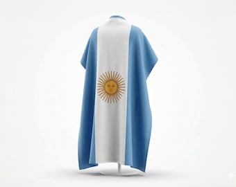 May include: A poncho-style garment, featuring the flag of Argentina. The design includes a central white stripe with a golden sun emblem, flanked by light blue panels. The garment is displayed on a white stand.