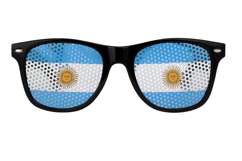 Puede incluir: Gafas de sol negras con la bandera argentina en las lentes. La bandera presenta un diseño de rayas celeste y blancas con un sol dorado en el centro. Las gafas tienen una montura rectangular clásica.