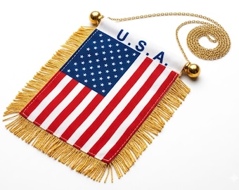 May include: A small American flag banner with red and white stripes and a blue field of stars. The banner has gold fringe and is attached to a gold chain with gold ball finials. The word "U.S.A." is printed on the white header.