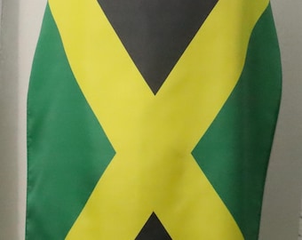 May include: A black, yellow, and green flag of Jamaica draped over a person's shoulders. The flag features a yellow cross that divides the flag into four sections. The top and bottom sections are black, and the left and right sections are green.