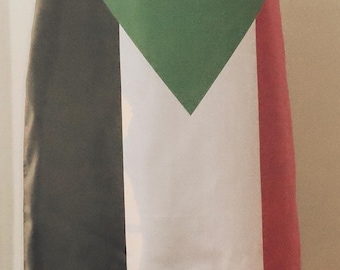 May include: A cape featuring the flag of Sudan. The cape has a green triangle, a white stripe, a black stripe, and a red stripe. The cape is draped over a person's shoulders.