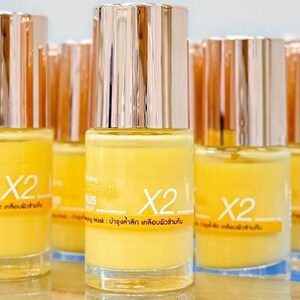 May include: A collection of yellow skincare product bottles with silver and gold caps. The bottles have the text "X2" and other text in a foreign language. The product is a collagen mask.