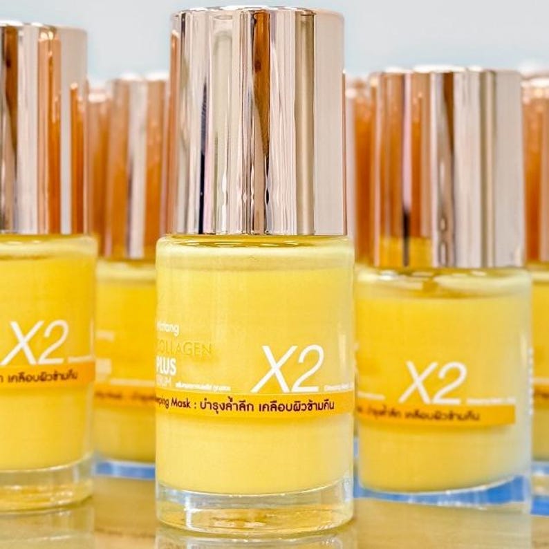 May include: A collection of yellow skincare product bottles with silver and gold caps. The bottles have the text "X2" and other text in a foreign language. The product is a collagen mask.