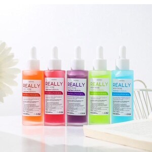 May include: Five bottles of body dose solution in orange, pink, purple, green, and blue. Each bottle has a white dropper and a white label with the word "REALLY" in large letters. The text "BODY DOSE" and "AHA SOLUTION 90%" are also visible.
