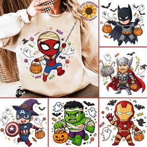 May include: Beige sweatshirt featuring Halloween-themed superhero graphics. The designs include Spider-Man, Batman, Thor, Captain America, Hulk, and Iron Man, each holding a pumpkin basket. Candy, ghosts, and bats surround the characters.