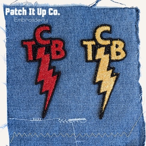 Op de afbeelding: Twee geborduurde patches op denim. Eén is rood met een bliksemschicht en de letters "TCB". De andere is goudkleurig met hetzelfde ontwerp. De tekst "Patch It Up Co. Embroidery" staat bovenaan.