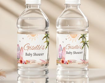 Puede incluir: Dos botellas de agua de plástico transparente con tapas blancas. Cada botella tiene una etiqueta con el texto "Giselle's Baby Shower" y un diseño con temática de playa que presenta una tabla de surf, palmeras y flores. El fondo es de color beige claro.